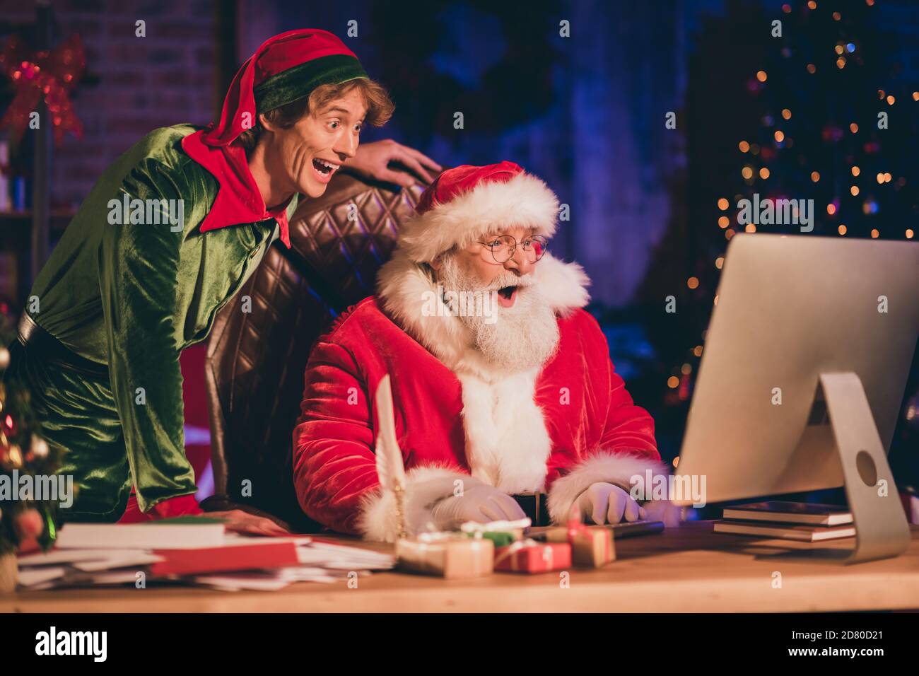 Photo portrait of shocked santa claus and elf browsing internet on pc Stock  Photo - Alamy