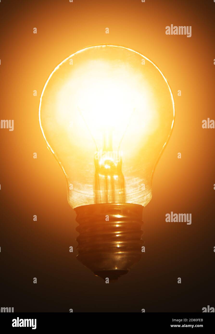 glowing light bulb on dark background in a halo of light Stock Photo - Alamy