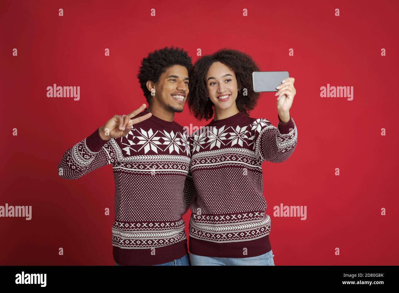 Couple of lovers in red Christmas clothes making selfie photo Stock Photo