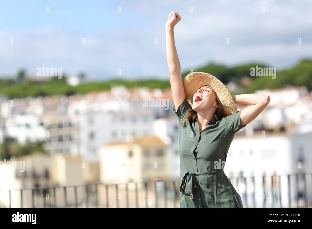 Excited tourist raising arm on summer vacation in a rural town a sunny day Stock Photo
