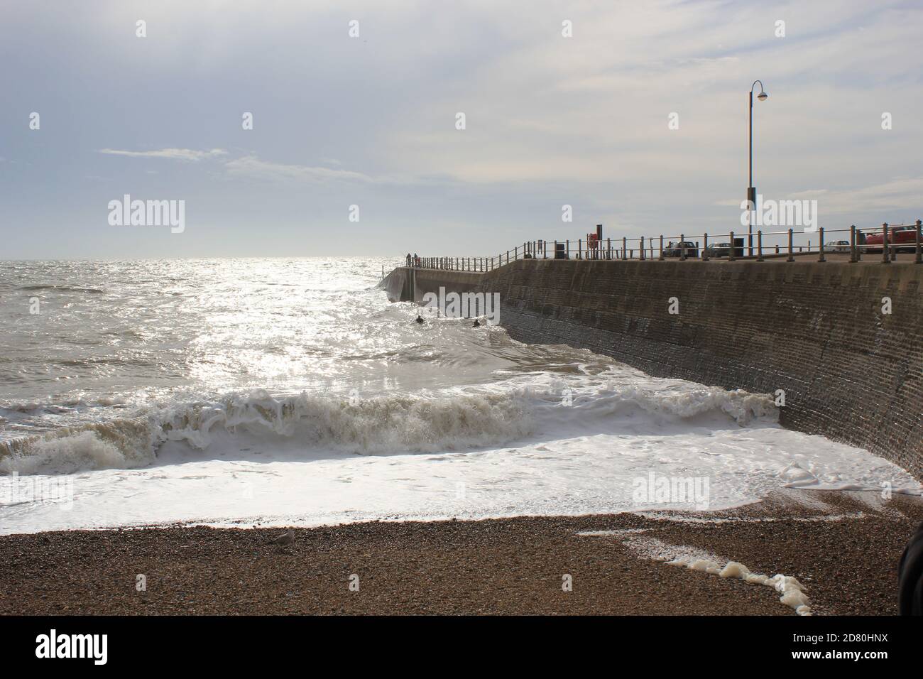 Hastings beach pier and seafront at sunset one man silhouette on