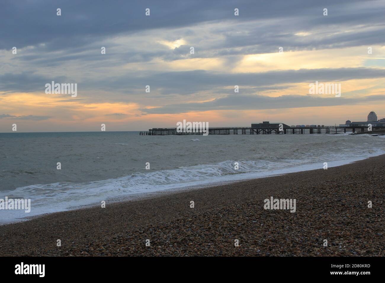 Hastings beach pier and seafront at sunset one man silhouette on