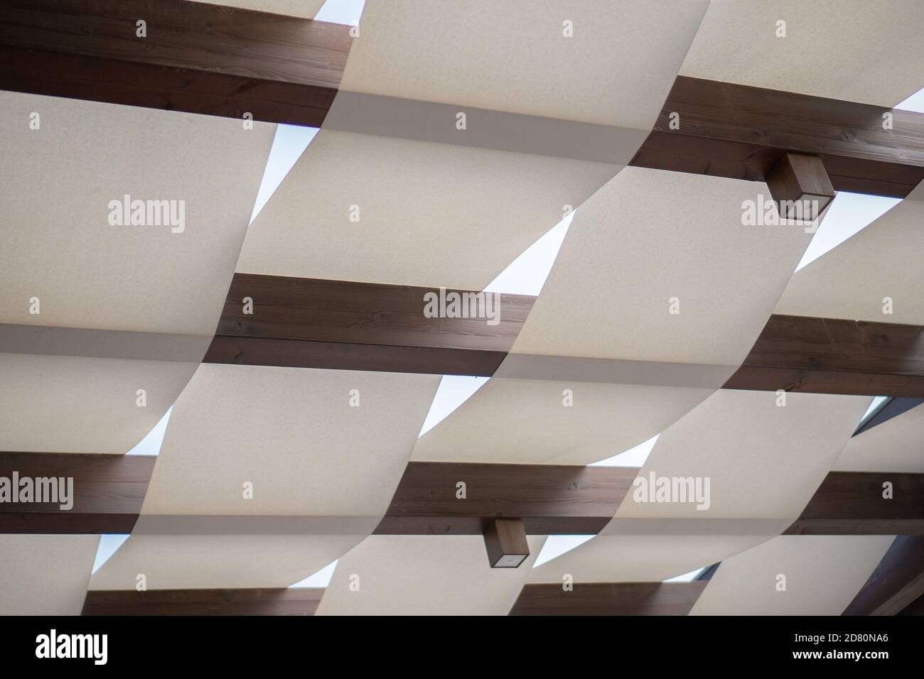 summer ceiling of wooden beams and white fabric and white sky Stock