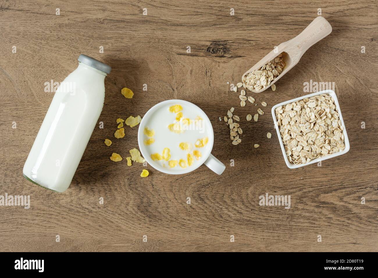 Homemade non dairy alternative milk made from oat flakes. Vegan oat milk on wooden table top view. Stock Photo