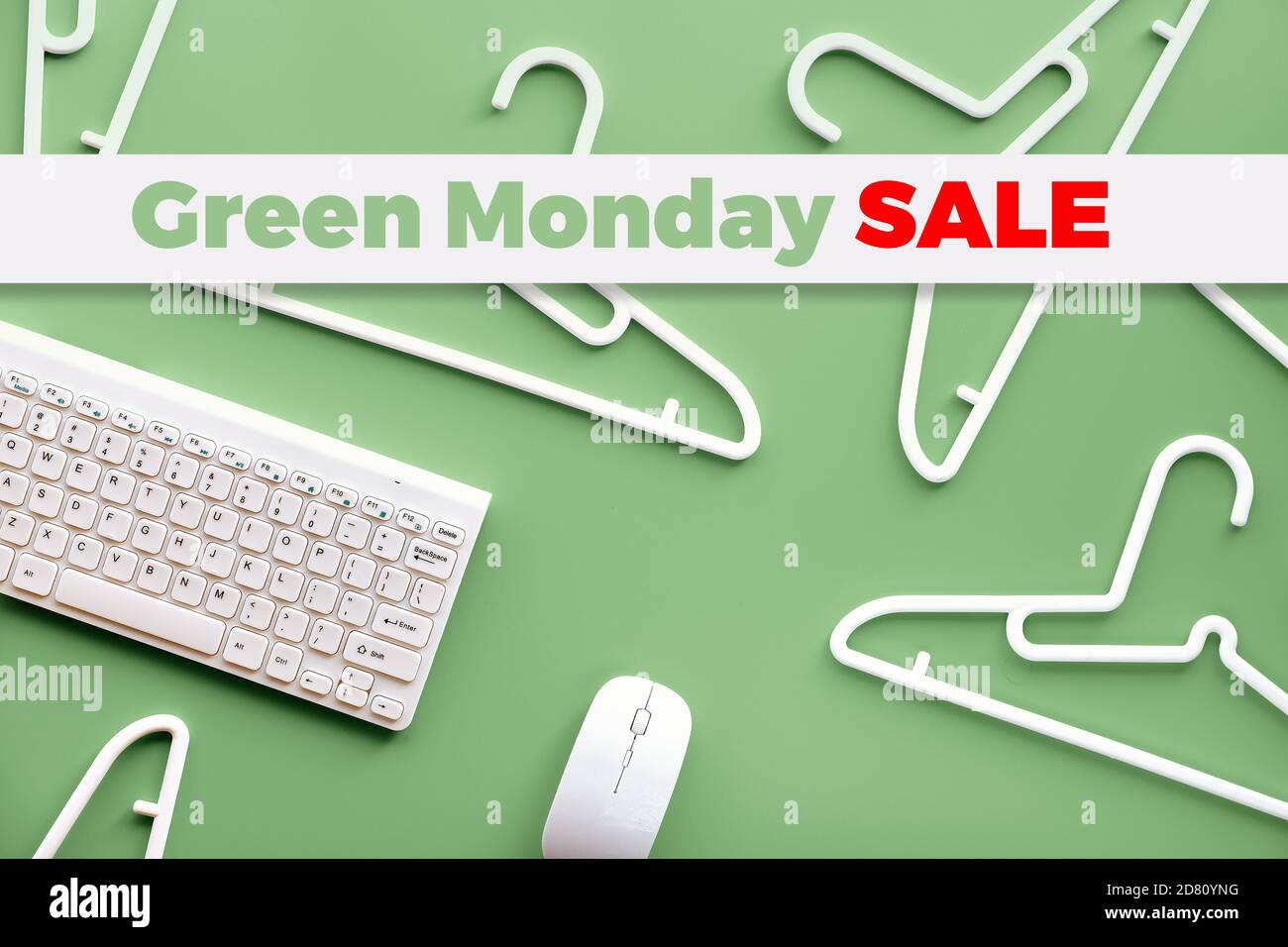 Green Monday sale text on green background with plastic hangers, keyboard and computer mouse Stock Photo