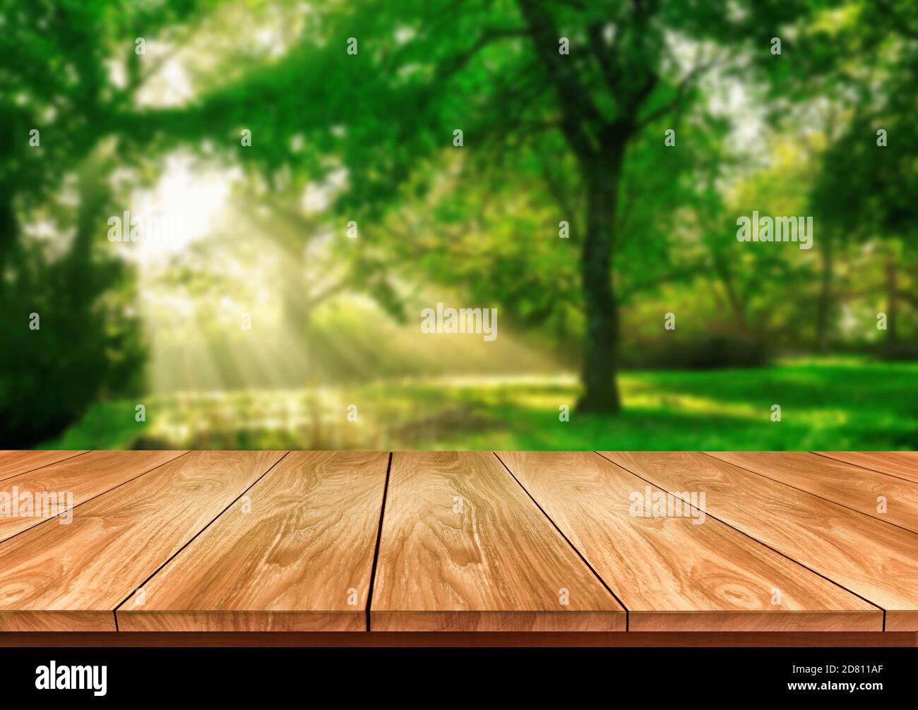 Brown wood table in green blur nature background of trees and grass in the park with empty copy space on the table for product display mockup. Fresh Stock Photo