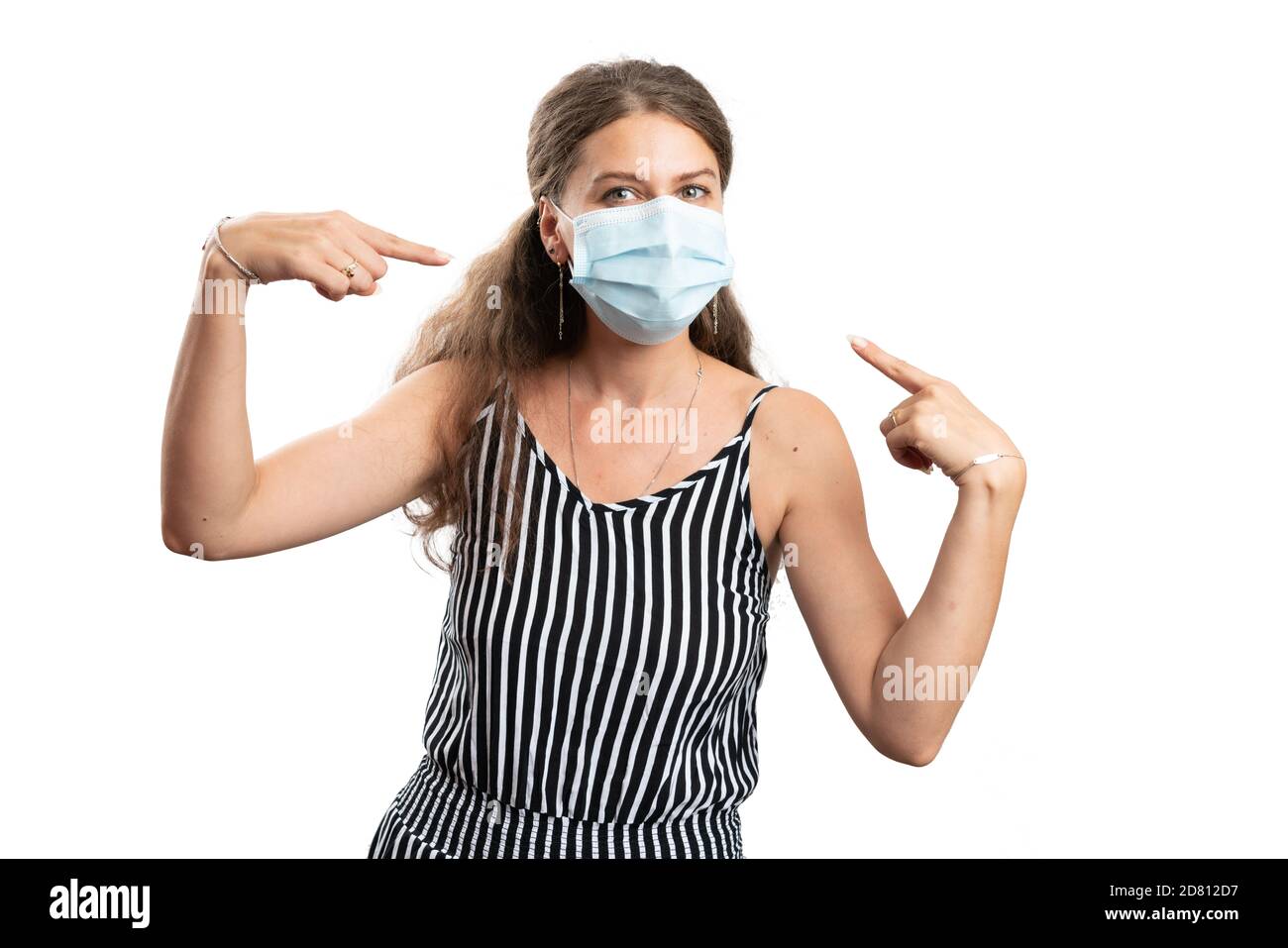 Adult female model pointing index fingers at disposable covid19 sars influenza virus protection medical or surgical mask as pandemic concept isolated Stock Photo