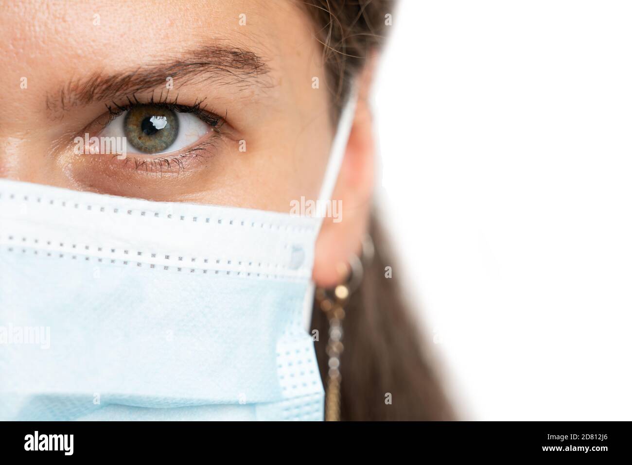 Half face close-up of adult woman model wearing disposable surgical or medical protection mask to prevent sars covid influenza virus infection in pand Stock Photo