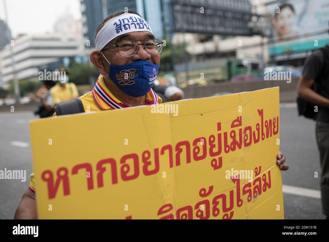 A pro-monarchy protester holds a placard during a demonstration outside the Embassy of Germany. Yellow-shirts protesters gathered outside the Embassy of Germany in Sathorn Road, to show their support for the monarchy, they also submitted a letter explaining the political situation in Thailand for the ambassador Georg Schmidt which was signed by Nititorn Lamlua and Pichit Chaimongkol from the “People of Thailand” movement. Stock Photo