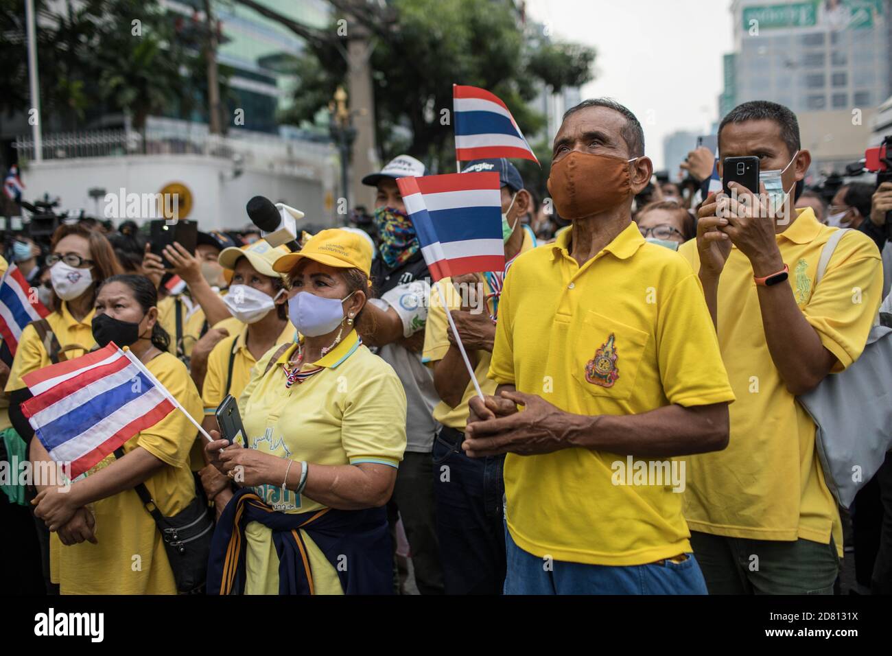 Pro-monarchy protesters seen listening to speeches during a demonstration outside the Embassy of Germany. Yellow-shirts protesters gathered outside the Embassy of Germany in Sathorn Road, to show their support for the monarchy, they also submitted a letter explaining the political situation in Thailand for the ambassador Georg Schmidt which was signed by Nititorn Lamlua and Pichit Chaimongkol from the “People of Thailand” movement. Stock Photo