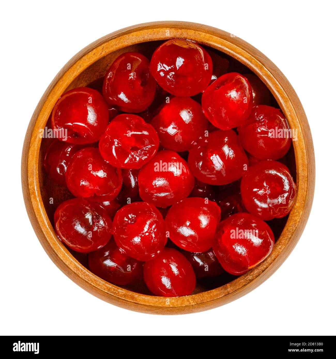 Maraschino cherries in a wooden bowl. Also cocktail cherries, whole red fruits of Prunus avium, preserved and sweetened in sugar syrup. Stock Photo