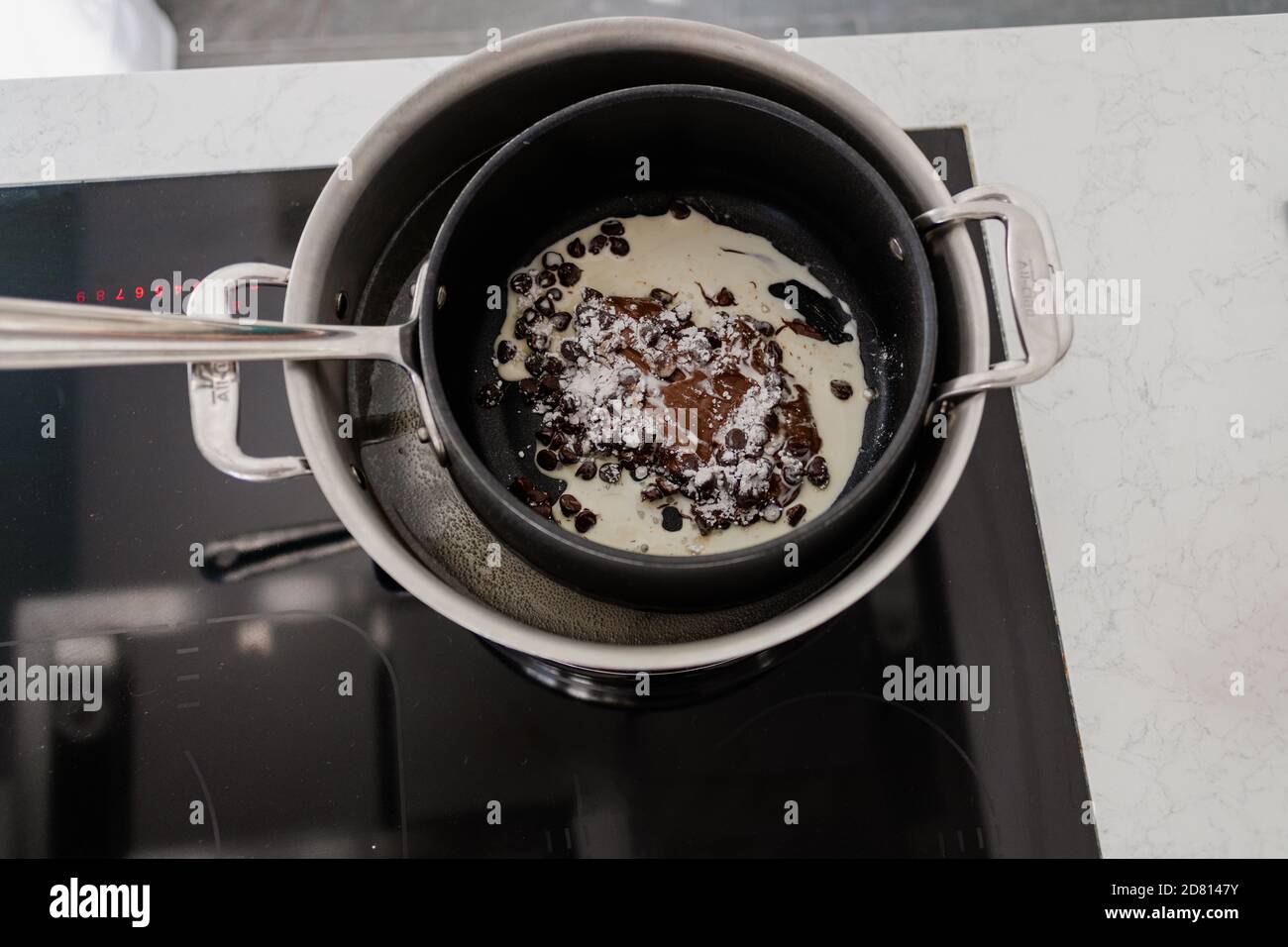 overhead view of chocolate melting on black stovetop Stock Photo Alamy