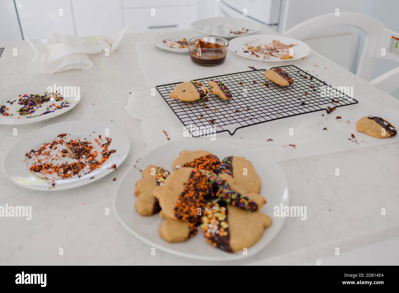 holiday cookies on messy kitchen counter with chocolate and sprinkles Stock Photo