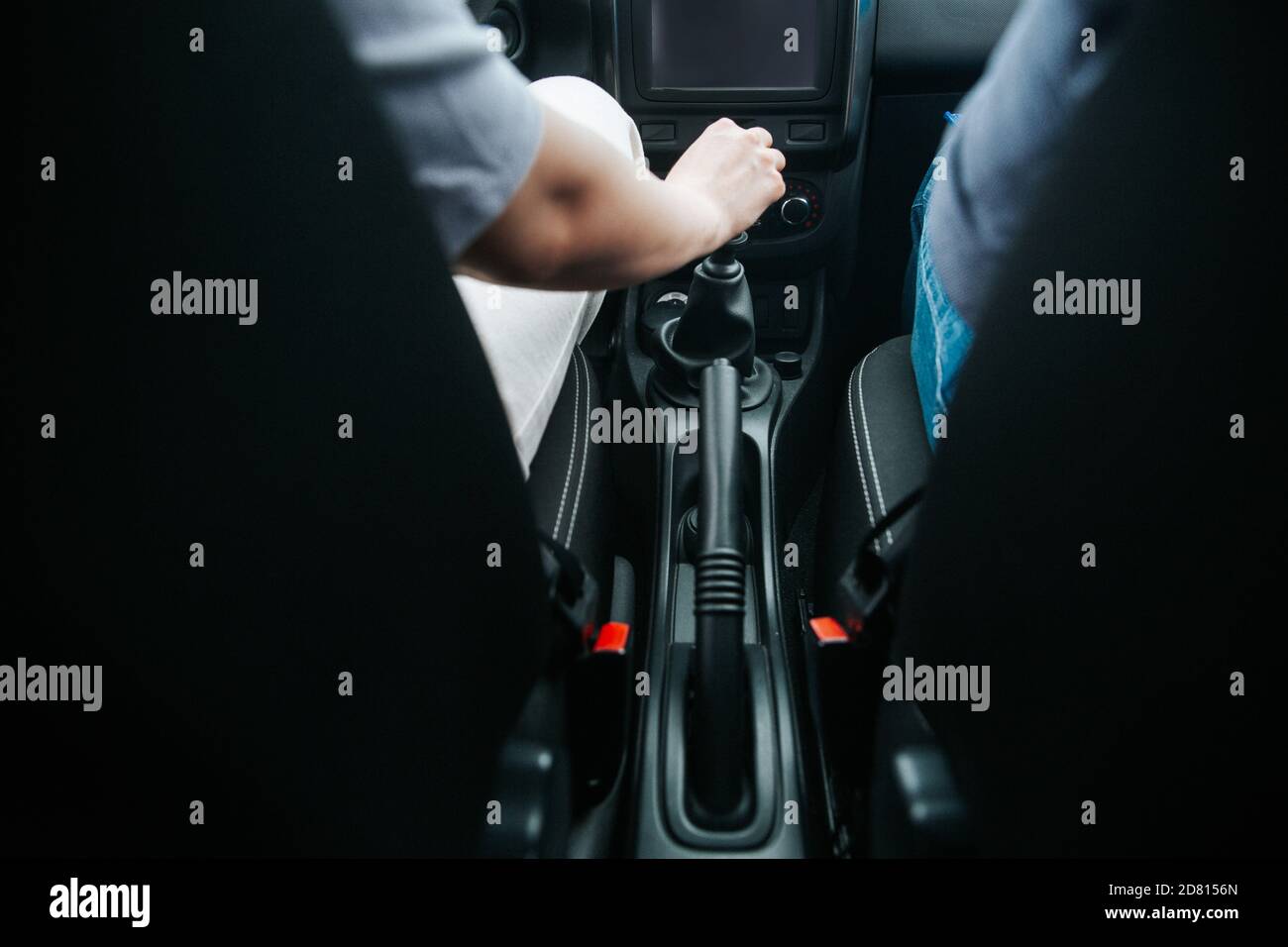 Male hand pulling an automatic gear shifter in a new car. Manual