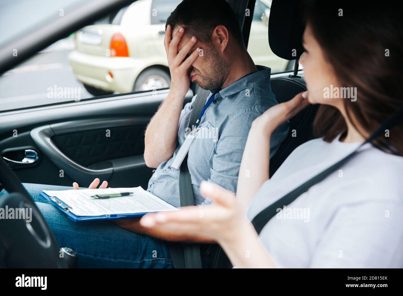 Upset male driving examiner in gray shirt and jeans makes facepalm ...