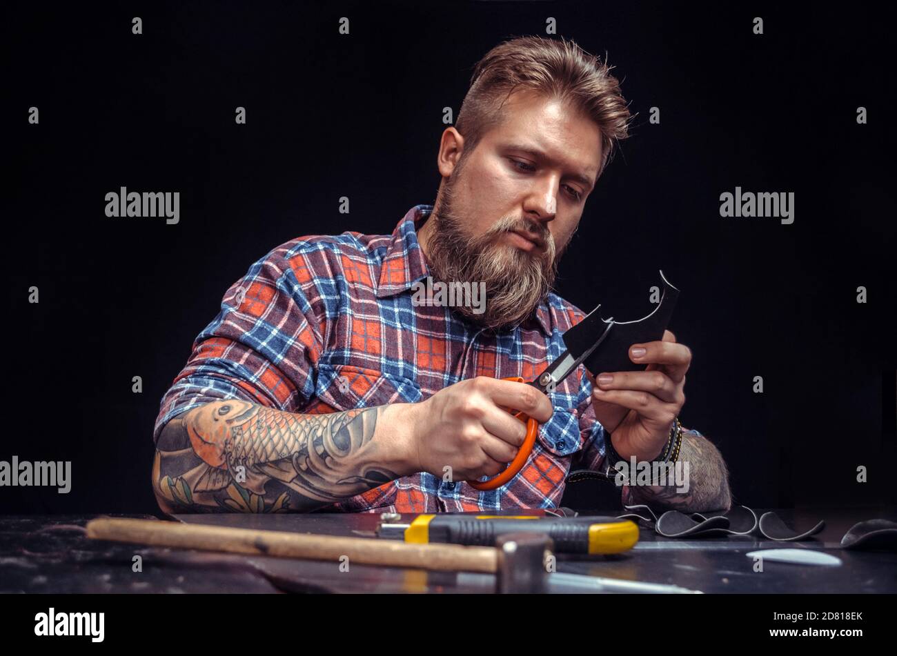 Leather Currier processes a workpiece from leather Stock Photo