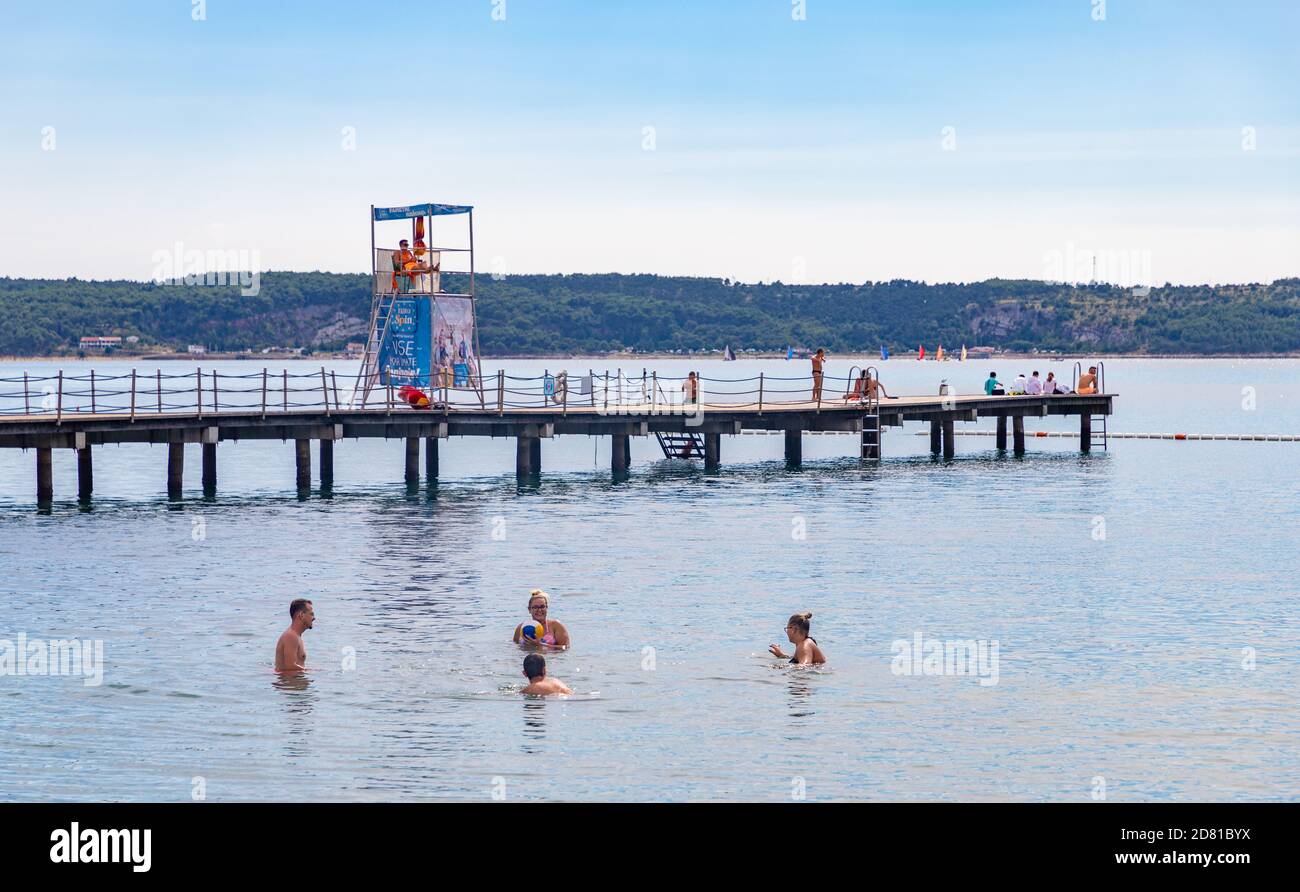 A picture of a small group of people bathing in the beach of Portorož. Stock Photo