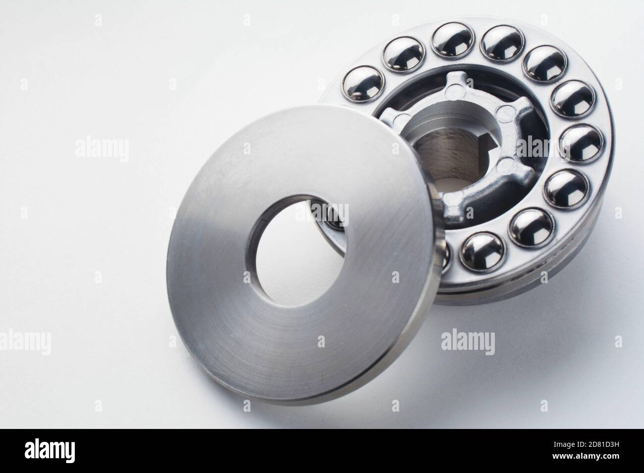 Stainless steel thrust ball bearing. Set of thrust ball bearing and shiny silver ball bearing. Spare parts for roller machine in heavy machinery and a Stock Photo