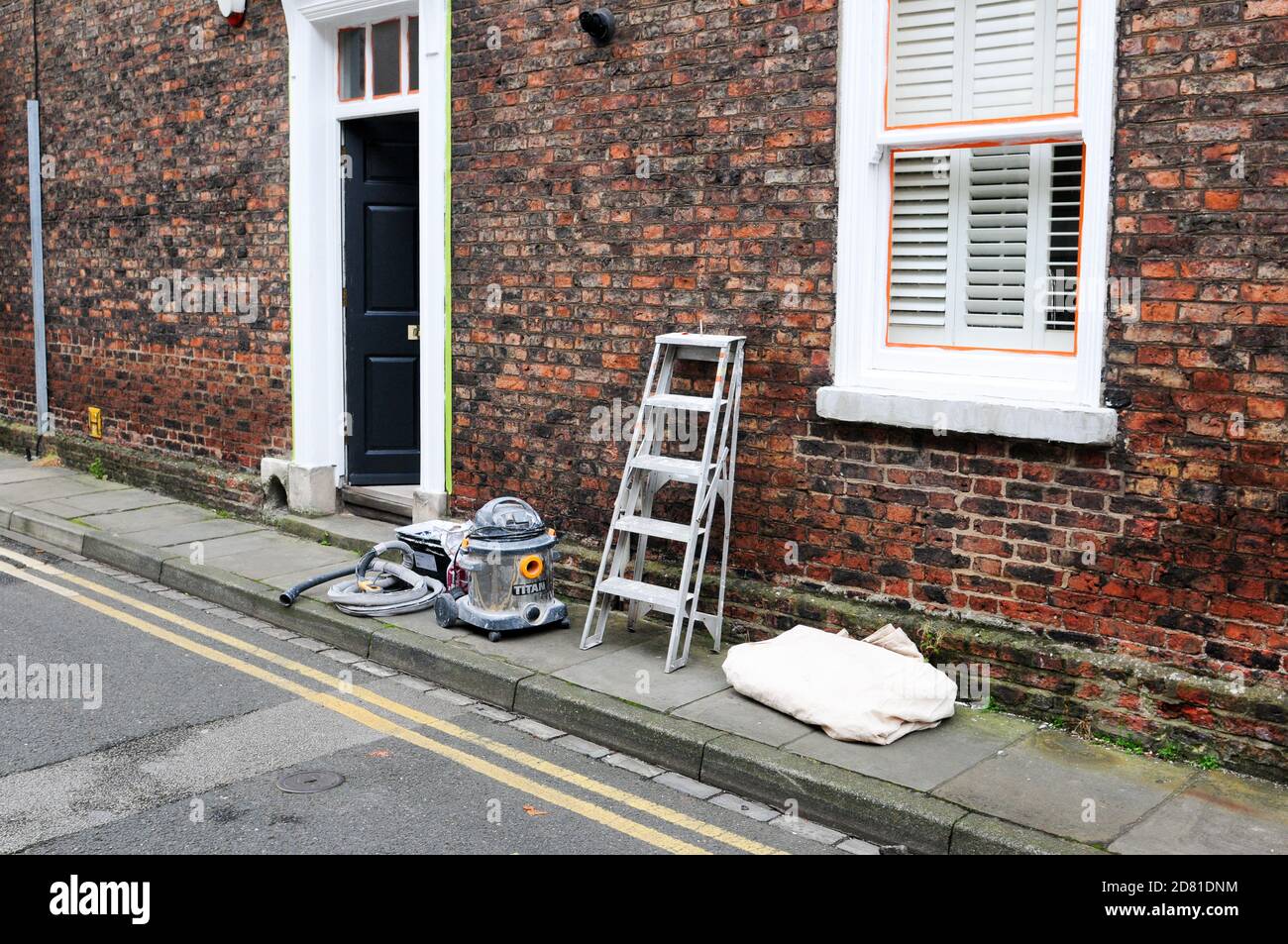 York,  UK, england, 24-10-2020, Exterior building with ladder leaning against the wall and hoover and dust sheet on pavement Stock Photo
