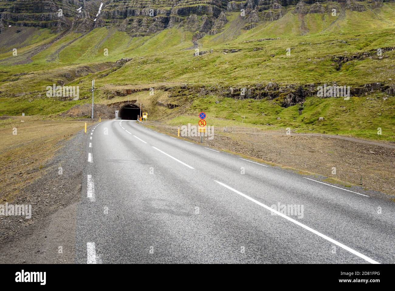 Road  going into a tunnel under a mountain In Iceland in spring Stock Photo