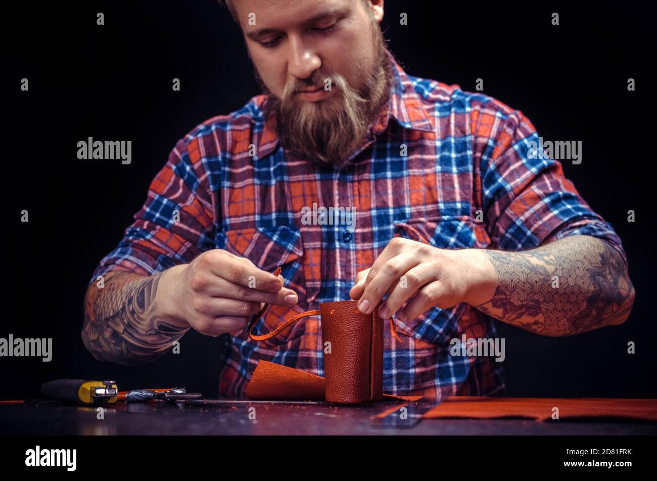 Man working with leather forms new leather product at his workshop Stock Photo