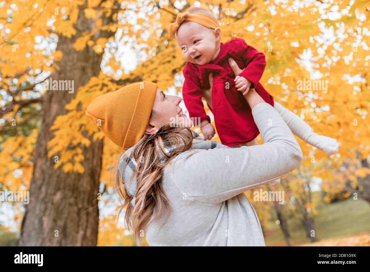 Baby daughter and her mother in the autumn season in park Stock Photo ...