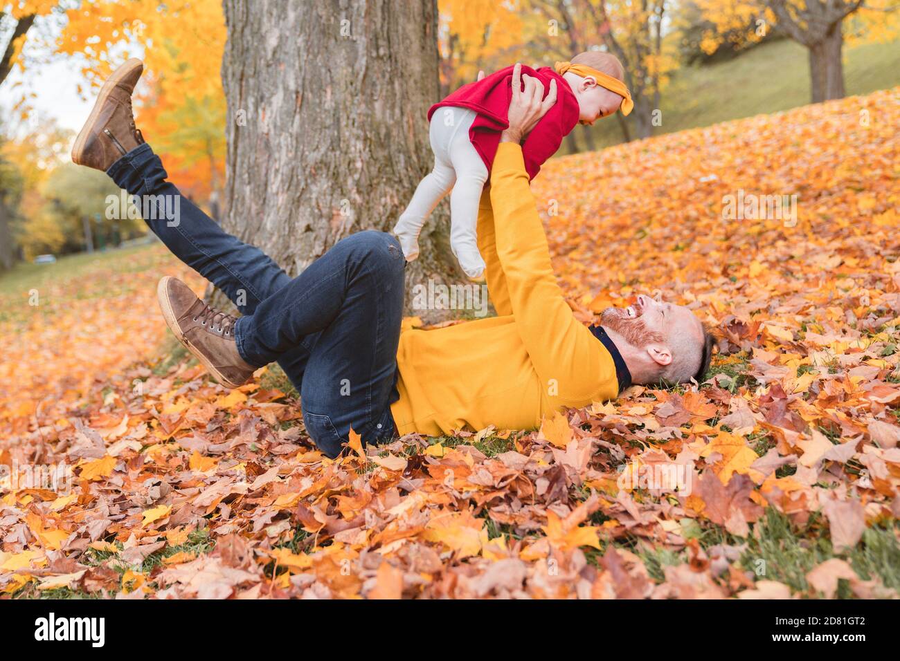 Baby daughter and her father in the autumn season in park Stock Photo ...