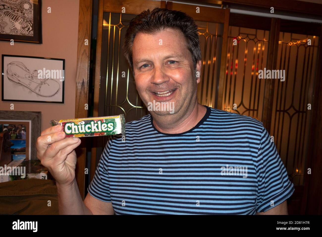 Thrilled man ready to enjoy an old time favorite Chuckles candy chuckling. Downers Grove Illinois IL USA Stock Photo