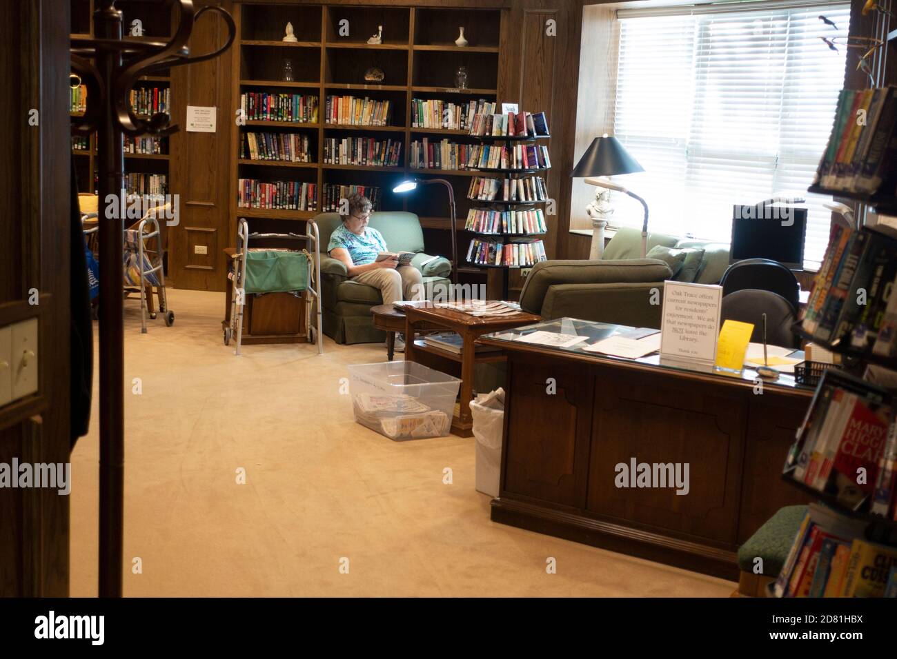 Woman reading in the quietude of the Oak Trace Senior Living library. Downers Grove Illinois IL USA Stock Photo