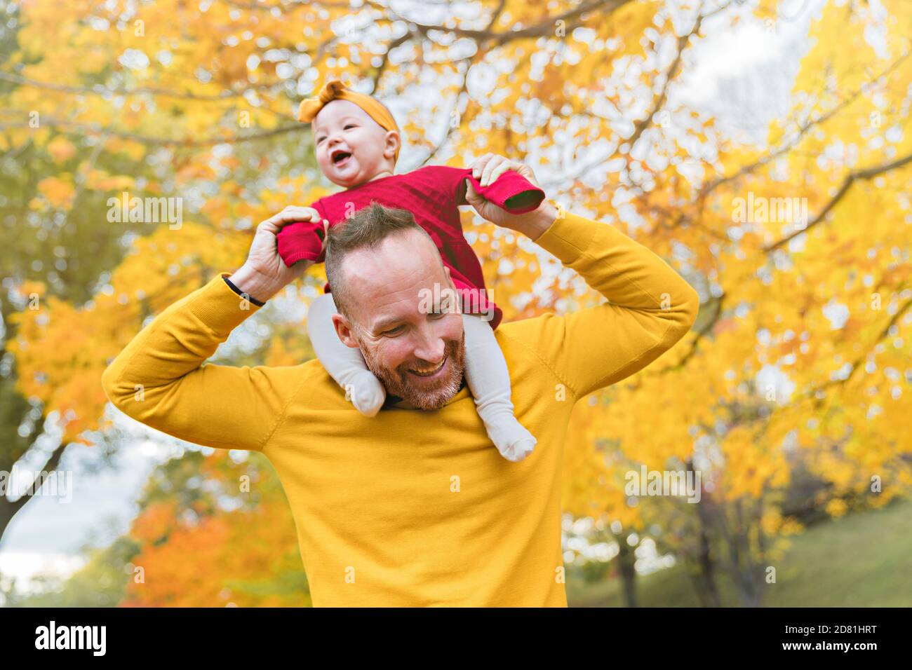 Baby daughter and her father in the autumn season in park Stock Photo ...