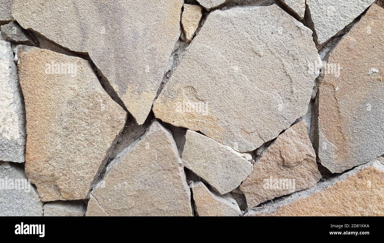 Stone pieces mosaic wall background. Rough stone textured background