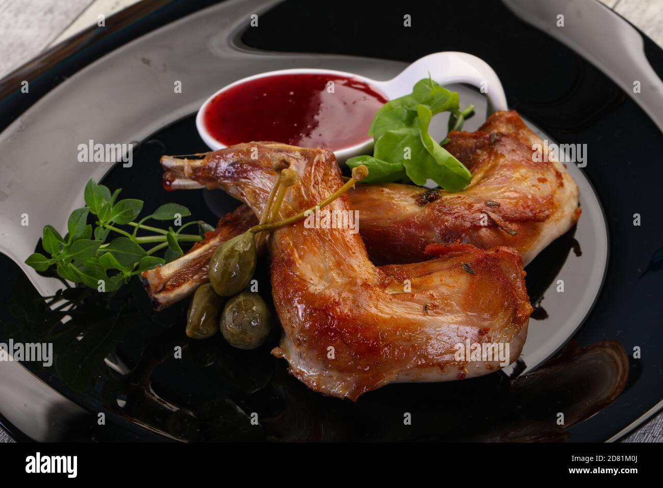 Roasted rabbit legs with cowberry sauce Stock Photo Alamy