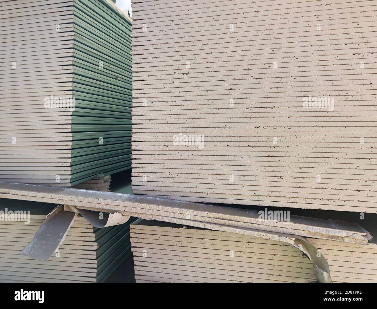 Piled sheets of drywall. Stacked plasterboard sheets. Gypsum cardboard