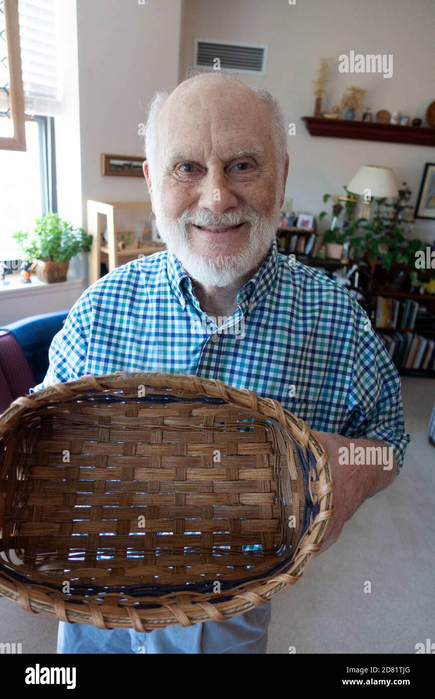 Proud weaver displaying a basket that he had woven in the senior retirement community where he lives. Downers Grove Illinois IL USA Stock Photo