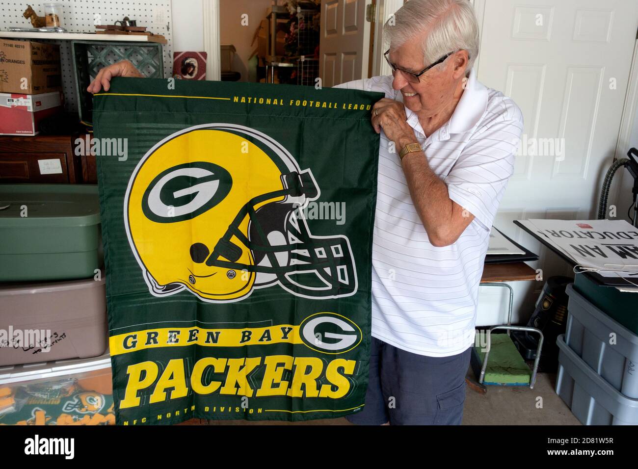 Senior football fan holds a Green Bay Packers blanket which has become a cherished possession. Downers Grove Illinois IL USA Stock Photo
