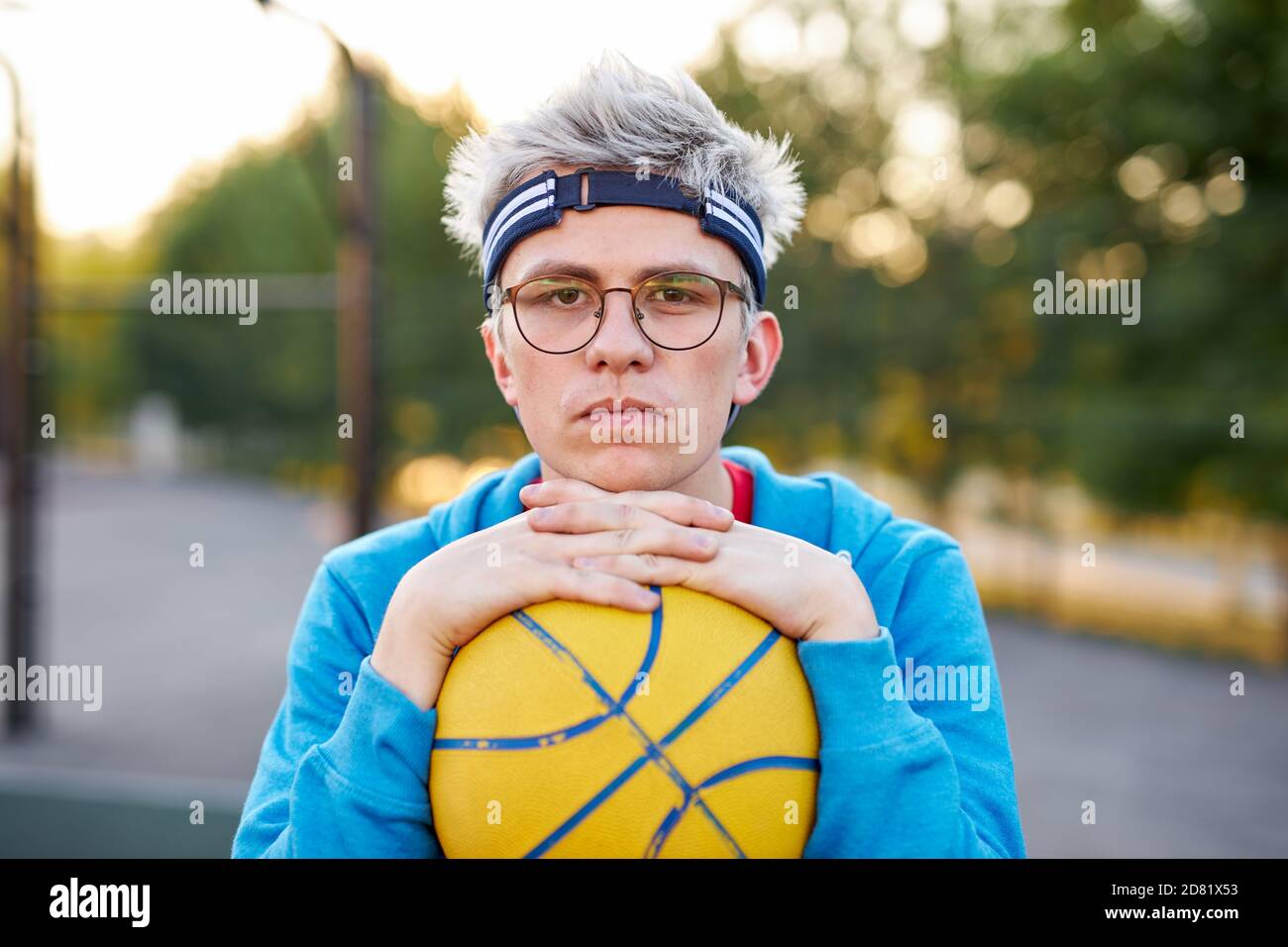 portrait of sportsman young boy with ball, guy came to play basketball after university lessons, have rest, enjoy Stock Photo