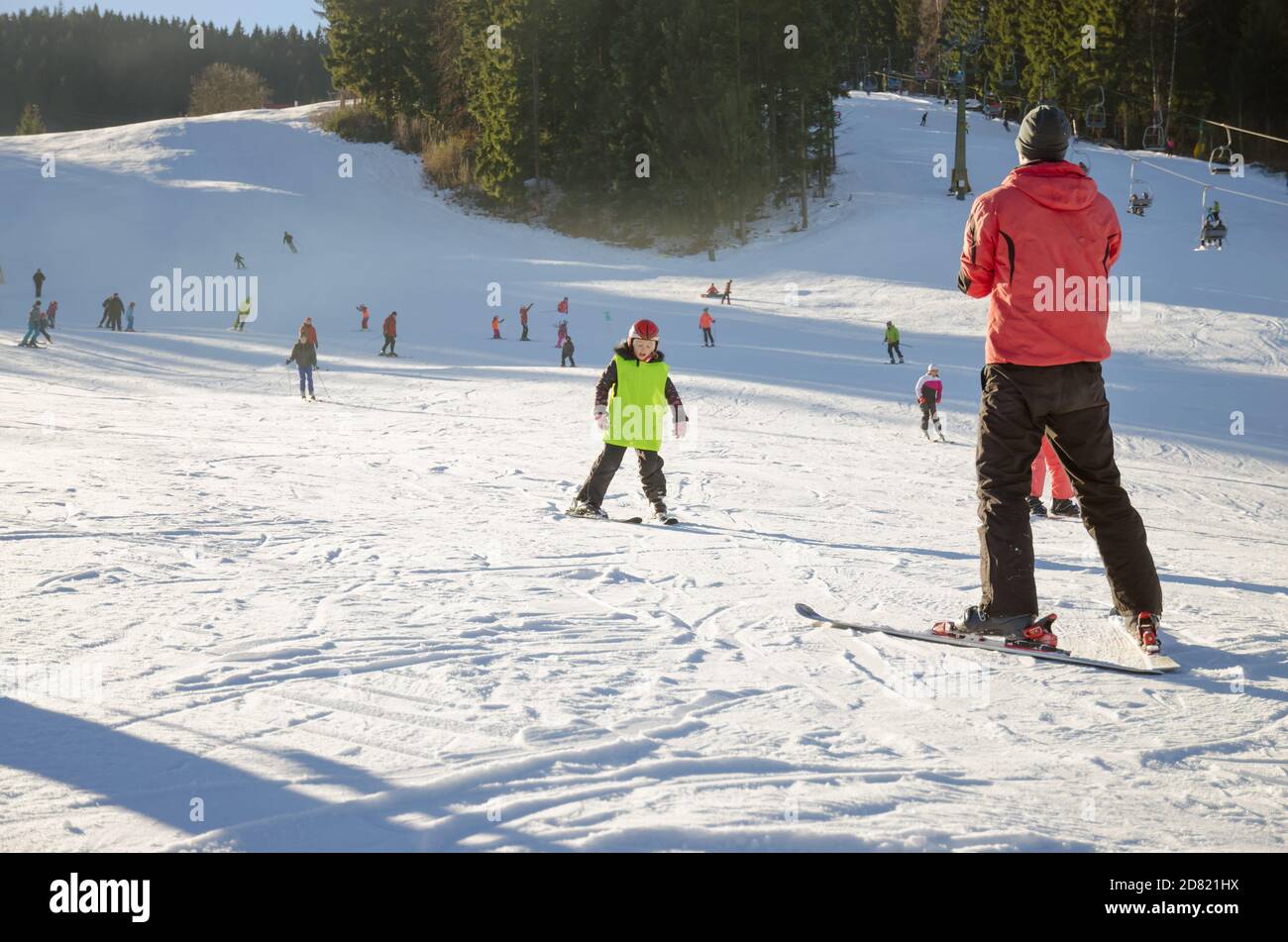 child and ski instructor in winter slope learning and teaching how to ski Stock Photo