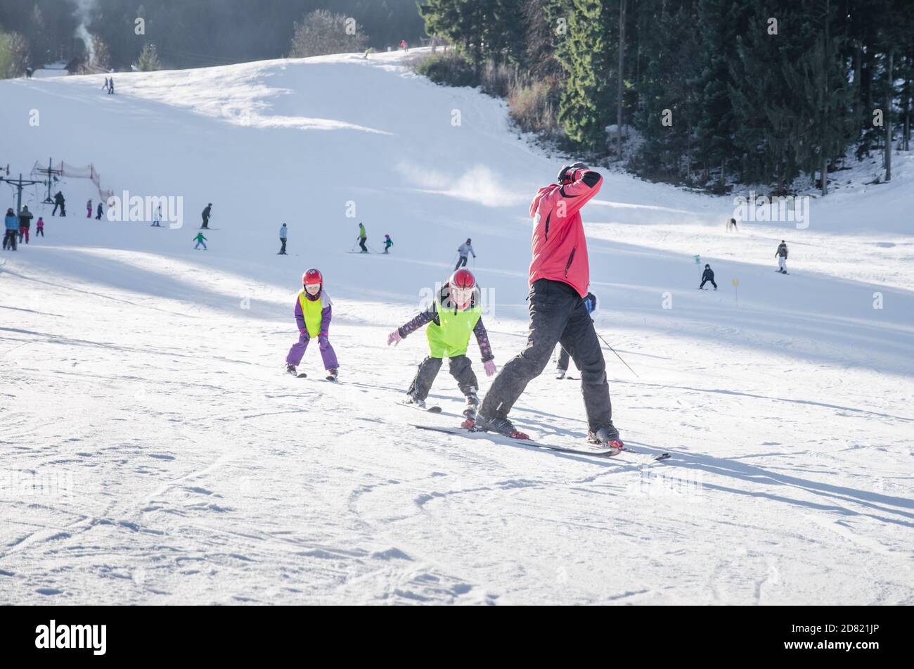 children and ski instructor in winter slope learning and teaching how to ski Stock Photo