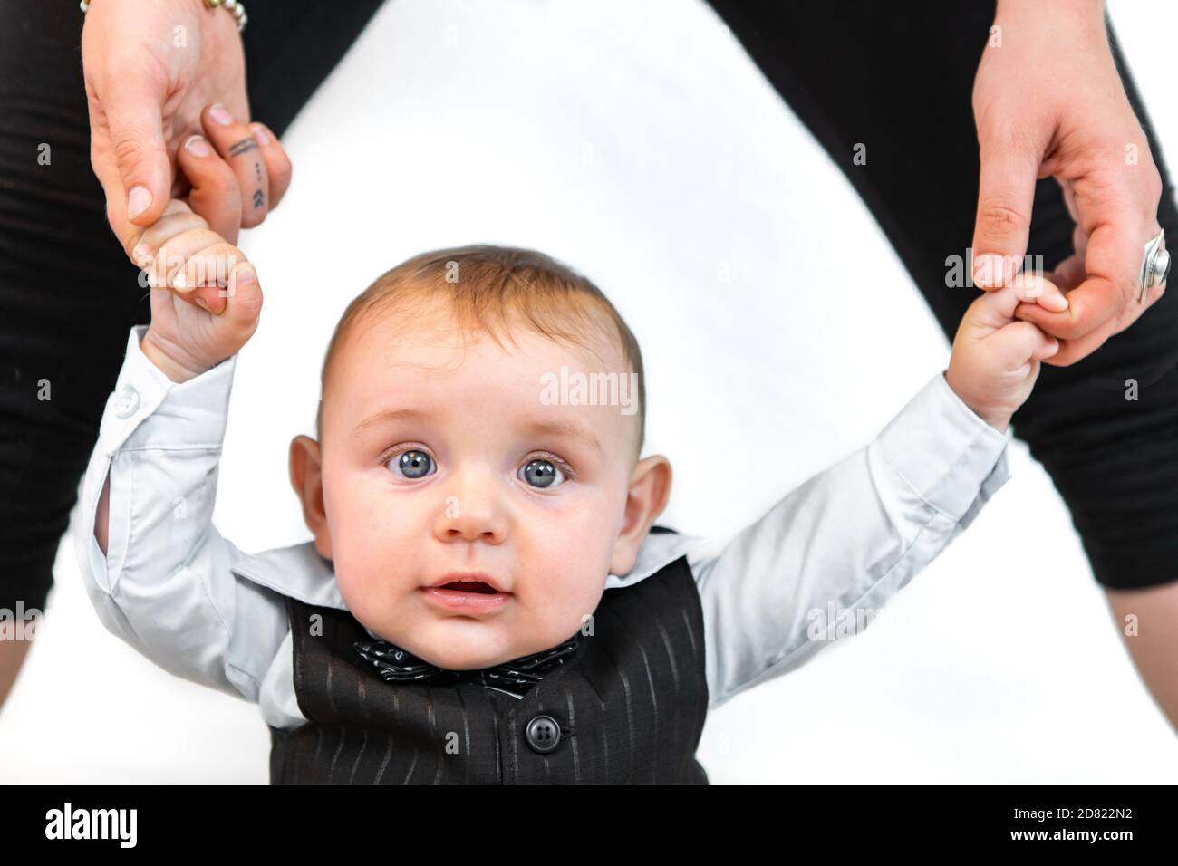 Portrait of newborn baby standing with parent hand support wearing