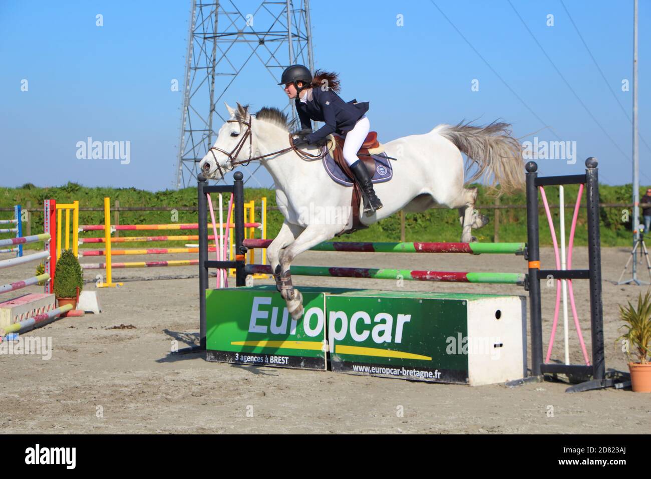 PLABENNEC, FRANCE - MARCH 25 : Woman and grey horse jump an obstacle during an equestrian event, March 25, 2017 Stock Photo