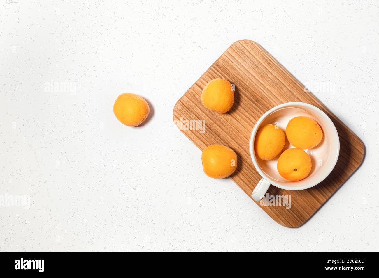 Apricot composition with wooden desk on white concrete background. Culinary web banner. Flatlay. Space for text. Place for text Stock Photo