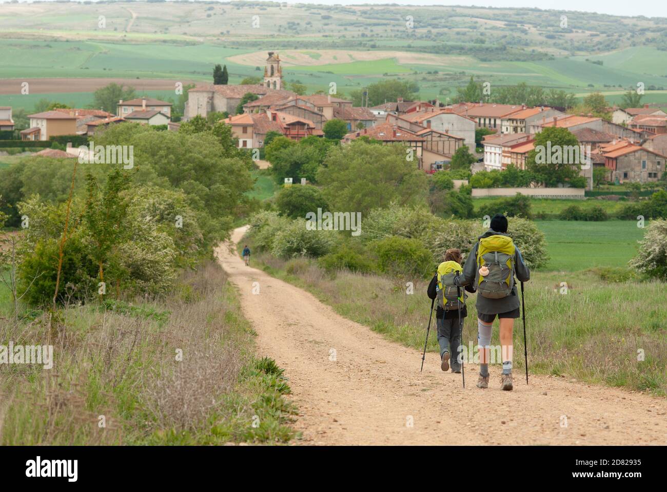 A couple of pilgrims entering the Spanish village of Agés, on the Camino de Santiago Francés. Stock Photo