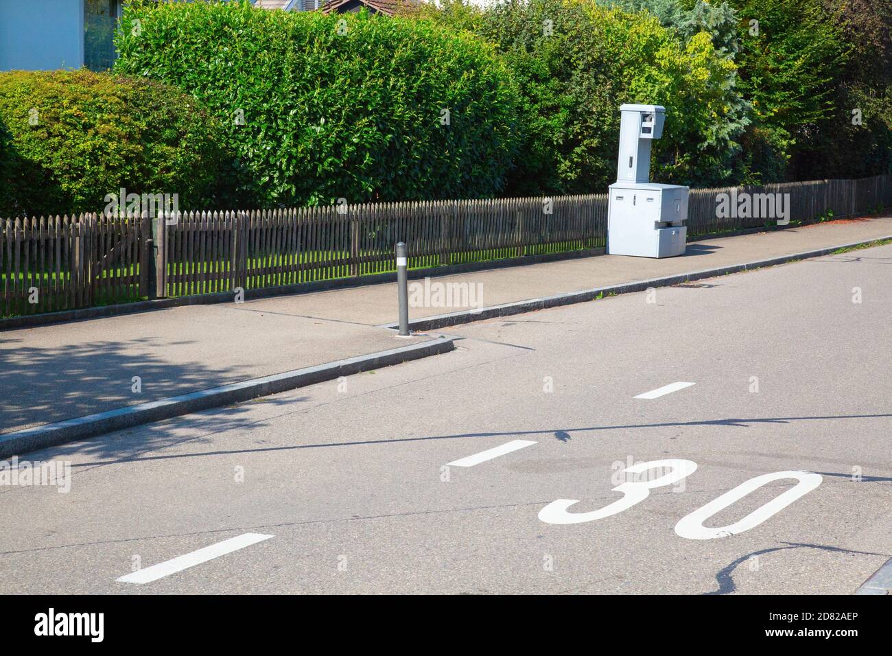 Speed camera on the narrow street of small swiss city. The 30 km/h is typical limit in the living zones in Switzerland Stock Photo