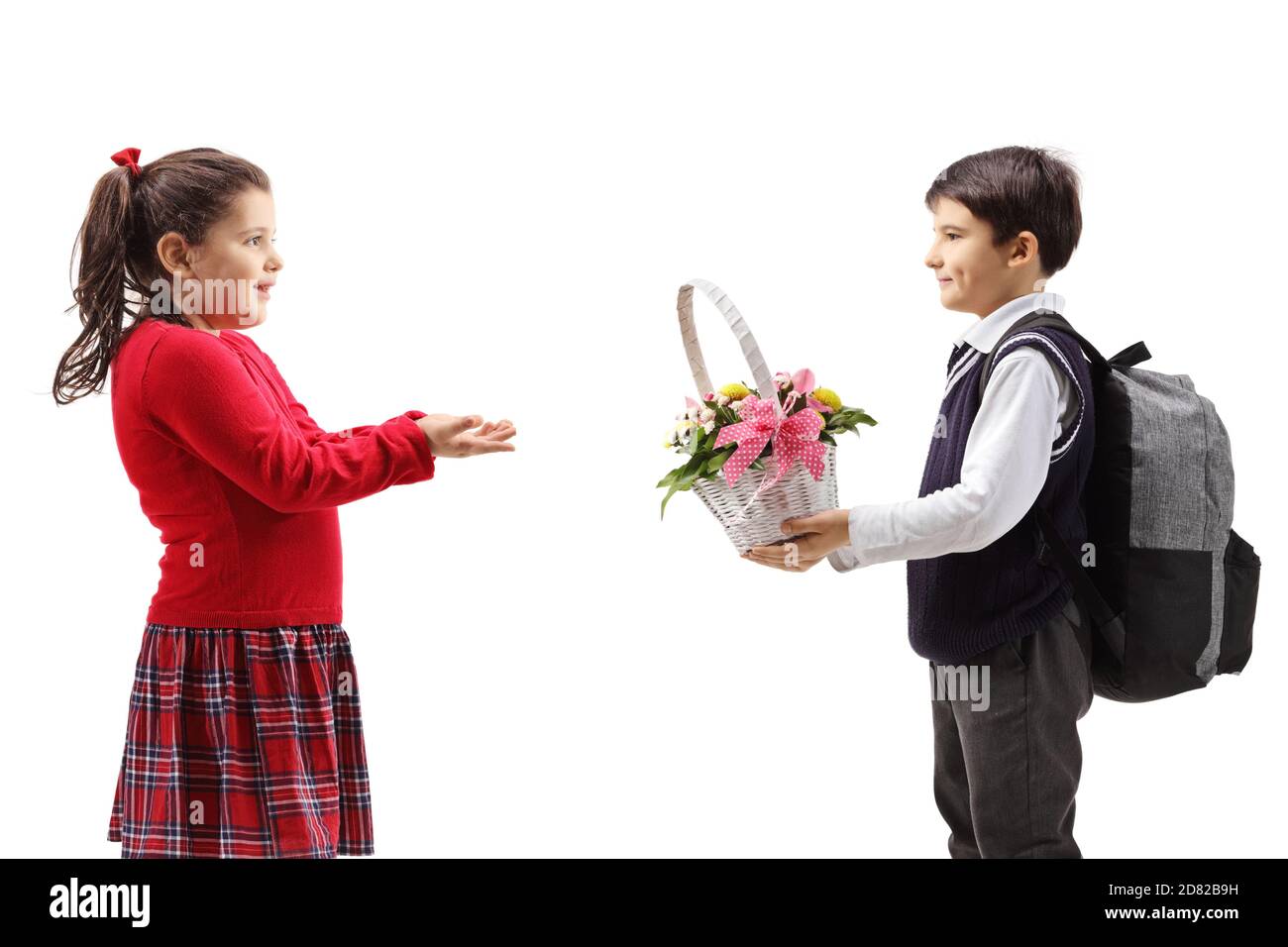 Boy giving a basket with flowers to a little girl isolated on white background Stock Photo