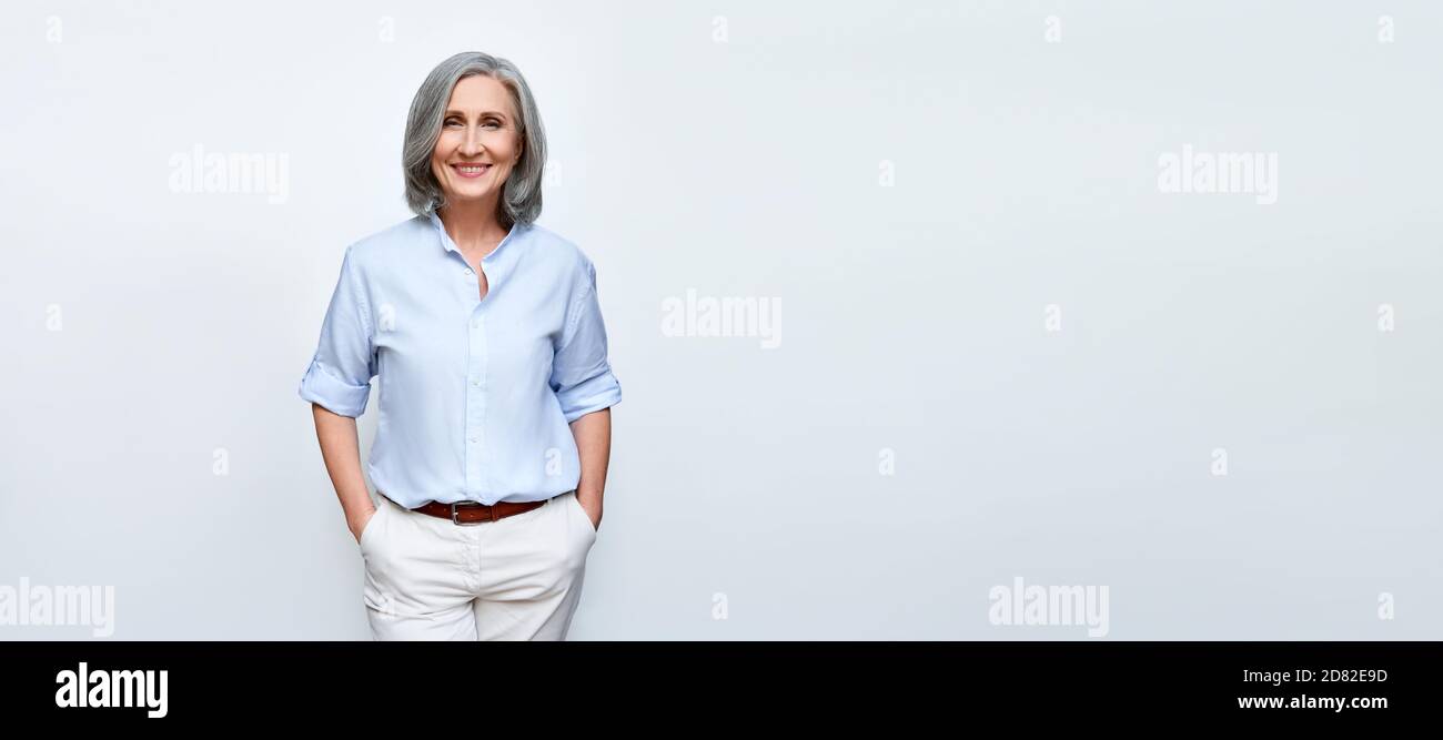Smiling mature business woman standing isolated on white background, banner. Stock Photo