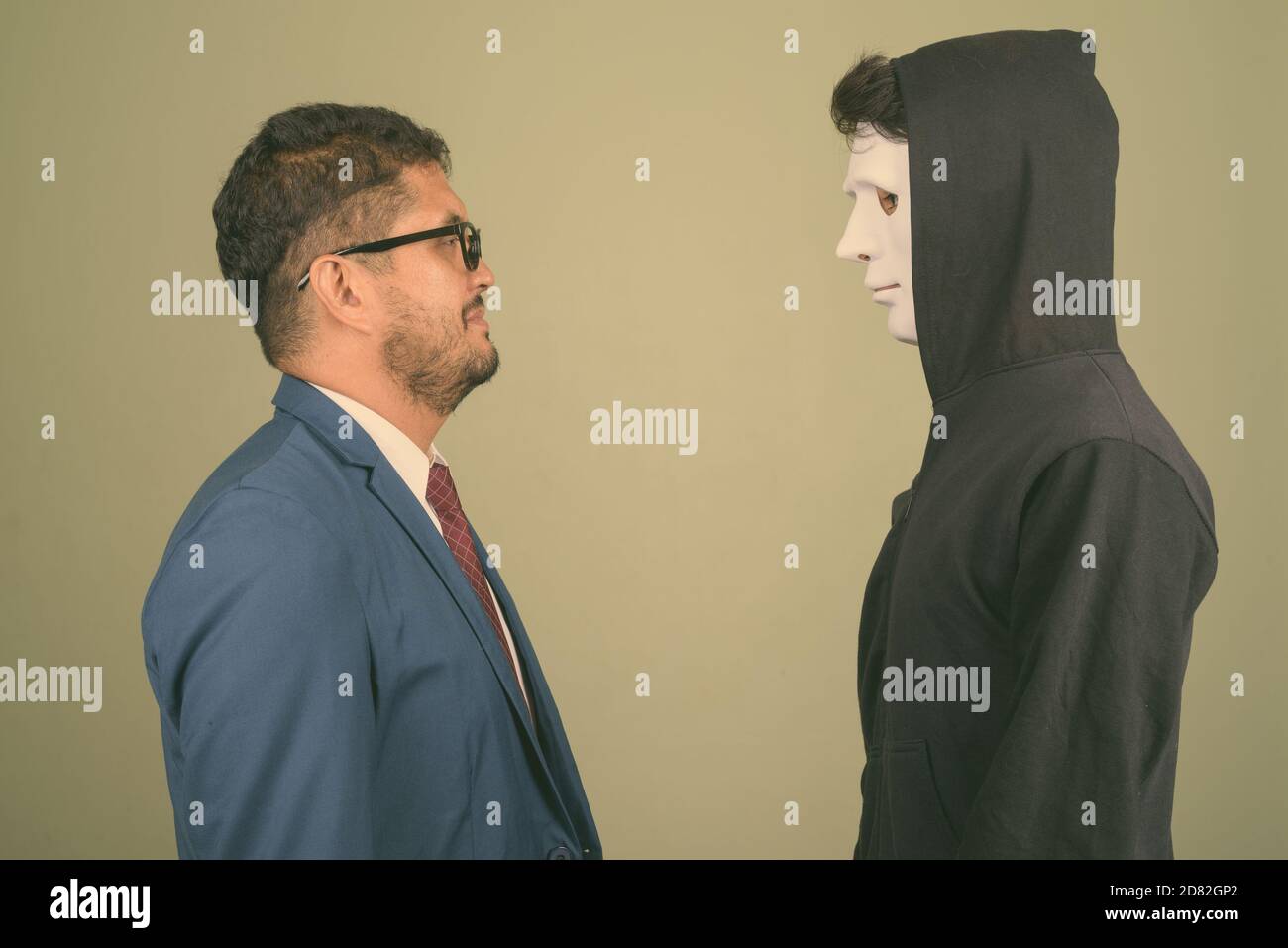 Bearded Persian businessman and young Indian man against colored background Stock Photo