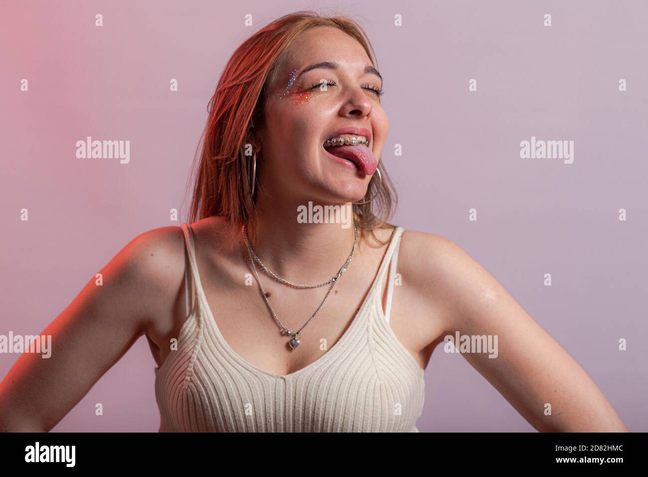 medium shot of wearing braces with eyes closed and tongue sticking out