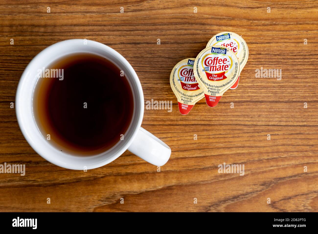 https://c8.alamy.com/comp/2D82PTG/galloway-nj-oct-4-2020-three-coffee-mate-single-serve-creamers-on-a-wooden-table-with-a-white-ceramic-mug-of-coffee-2D82PTG.jpg