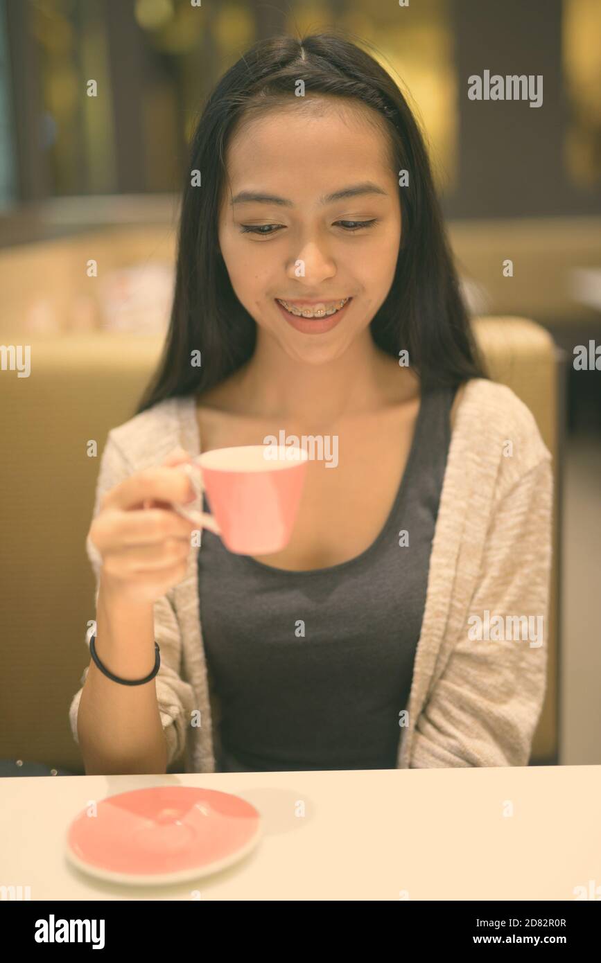 Young beautiful Asian woman relaxing inside the coffee shop Stock Photo ...