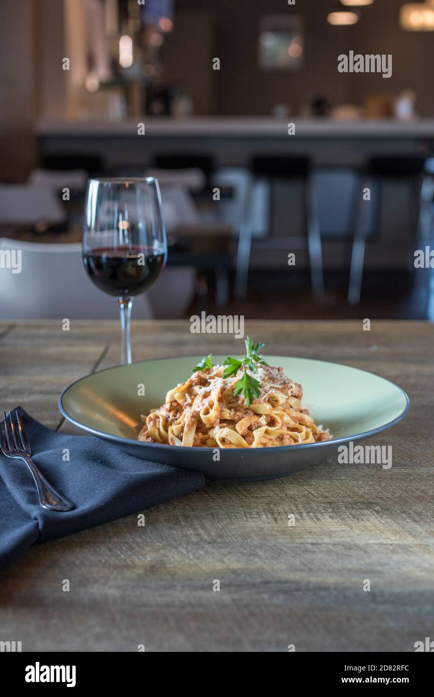 Bolognese pasta served with red wine in Italian restaurant Stock Photo